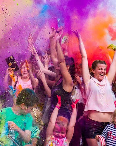 Students and kids jumping and throwing colorful dyed powder in the air